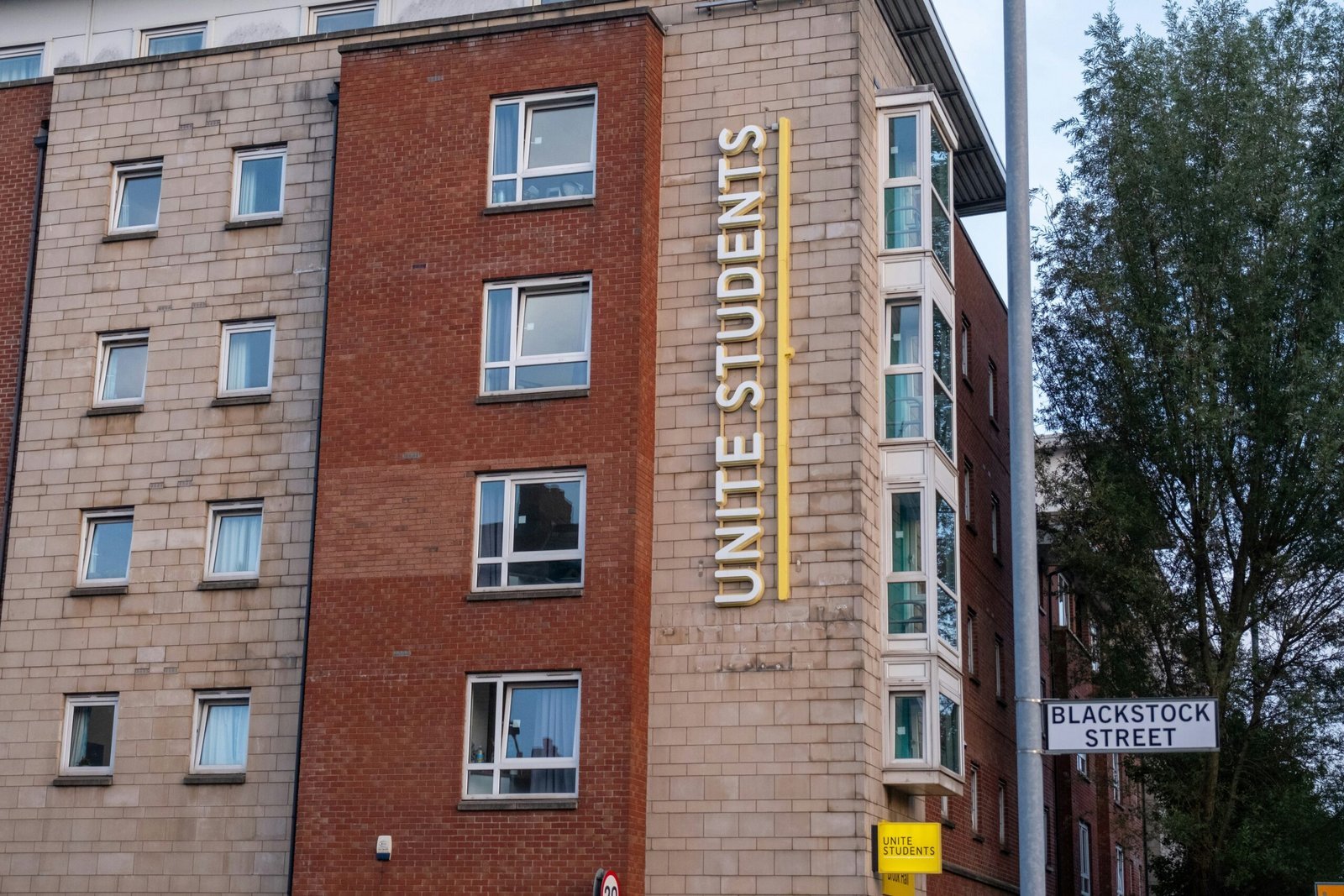 a tall brick building with a sign on the side of it